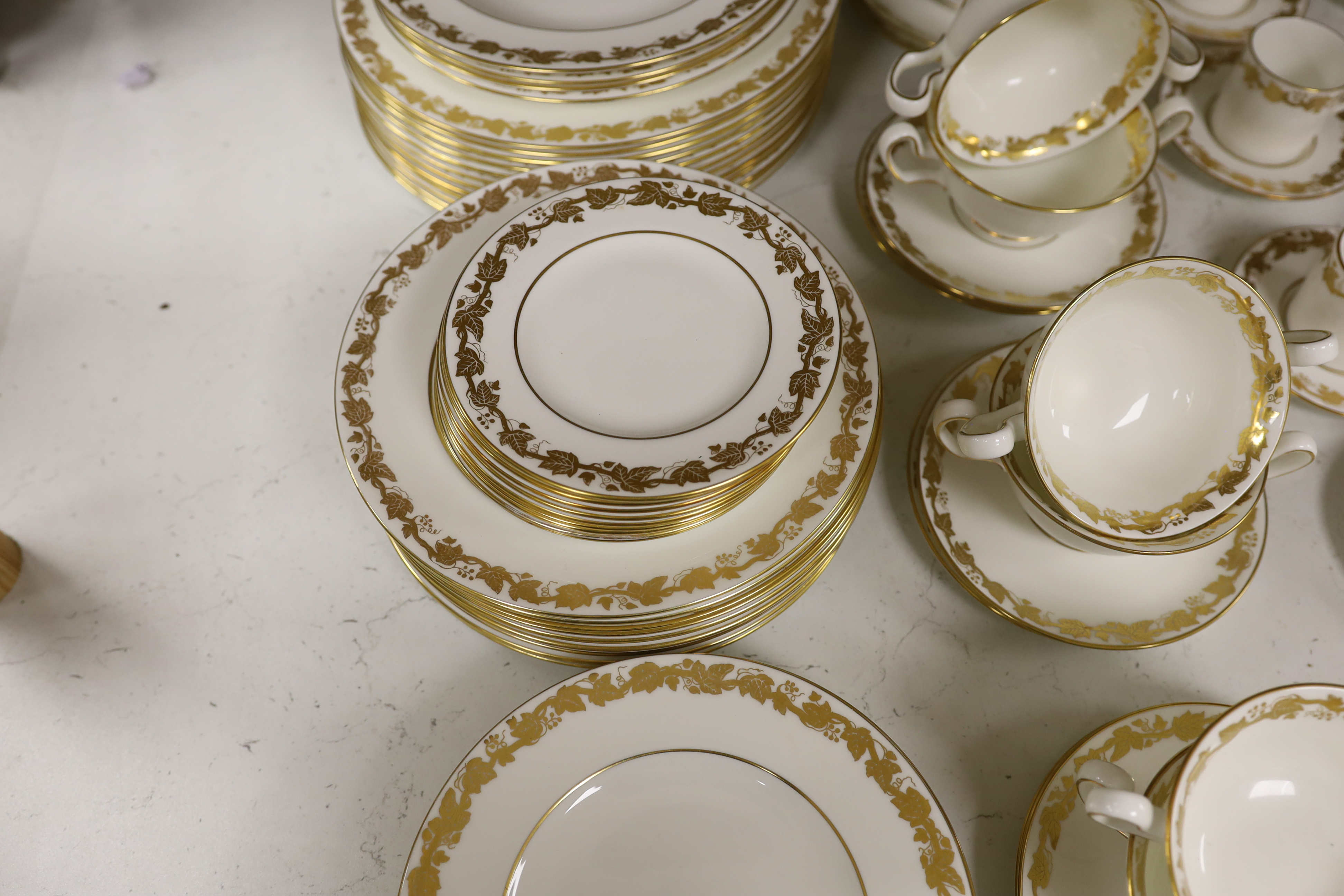 A Wedgwood gilt vine pattern dinner and coffee service for twelve